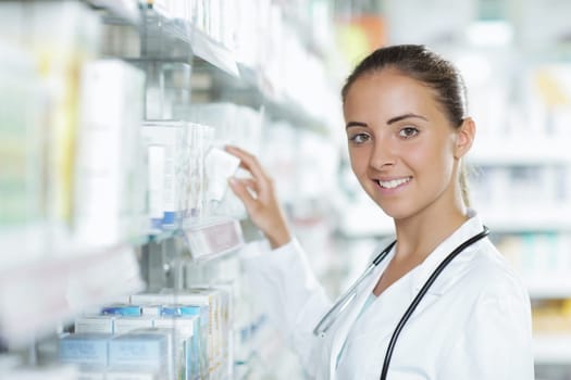 Portrait of a young female pharmacist selecting a medication