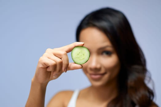 Young people and body care with portrait of happy asian girl smiling with cucumber for skin treatment