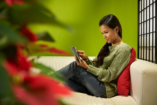 Young people and technology, Asian girl typing on digital tablet, pretty female student using computer and sitting on sofa at home