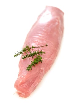 Raw pork tenderloin with thyme in portrait format