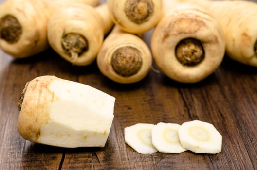 Parsnip peeled and sliced on wood