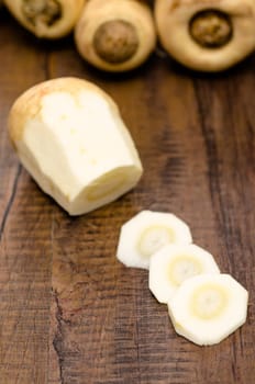 Parsnips in slices on wood in portrait format