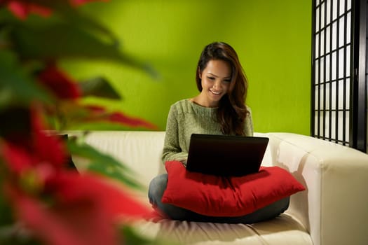 Young people and technology, happy Asian woman typing on laptop pc, beautiful female student using computer sitting on couch at home