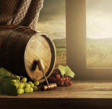 Wine barrel and grapes with vineyard on background