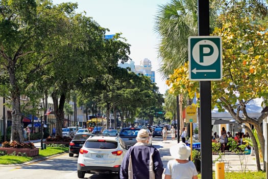 FORT LAUDERDALE, FLORIDA - FEBRUARY 3, 2013: Adult pedestrians shopping, walking and dining near downtown in a trendy tree lined retail district on a relaxing sunny winter day.