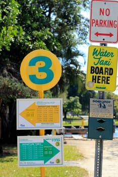 FORT LAUDERDALE, FLORIDA - FEBRUARY 3, 2013: Variety of outdoor signs showing up bound and down bound departure times for the water taxi, a boat that takes people on sightseeing rides near downtown.