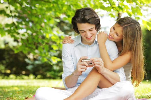 a couple of lovers, view photos on the display of their compact camera
