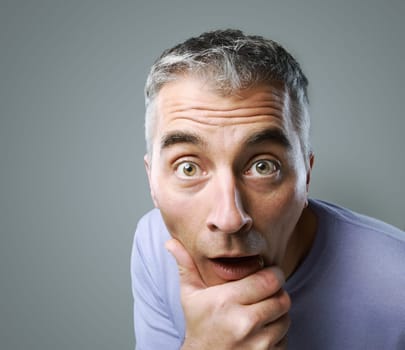 Portrait of casual man surprised on grey background