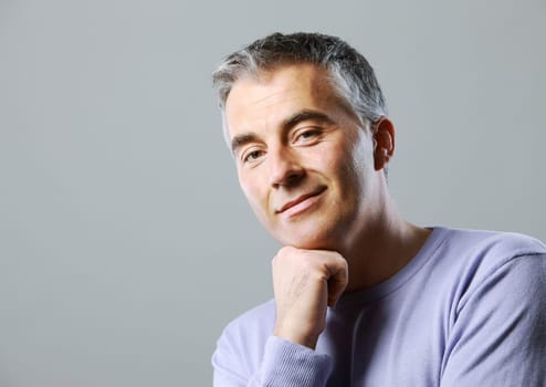 Portrait of casual man smiling on grey background