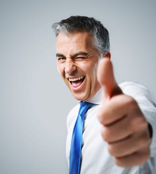 Happy mature business man showing thumbs up sign