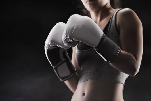Woman boxer, focus on boxing glove, shallow deep of field