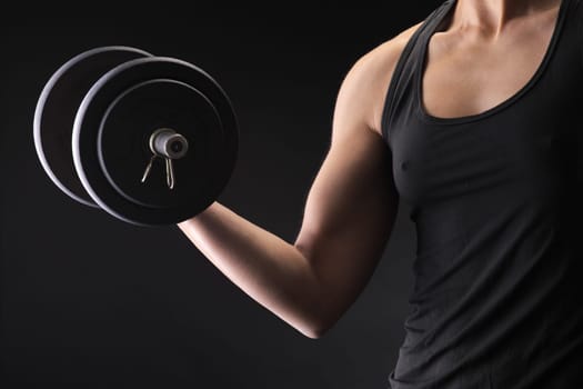 Young woman lifting the dumbbells
