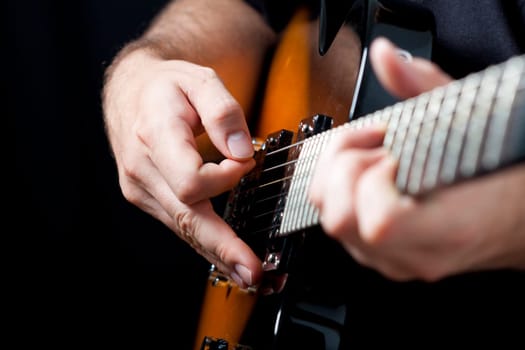 Close up on hands playing on electric guitar