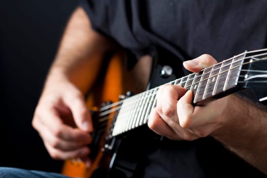 Close up on hands playing on electric guitar