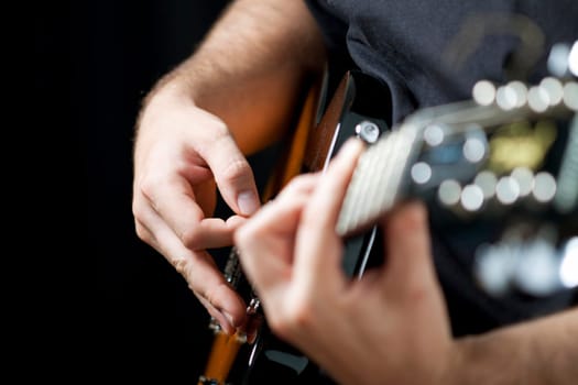 Close up on hands playing on electric guitar