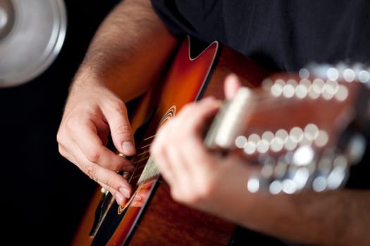 Close up on hands playing on folk guitar
