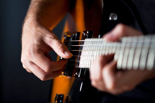 Close up on hands playing on electric guitar