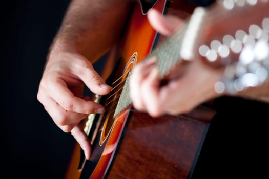 Close up on hands playing on folk guitar