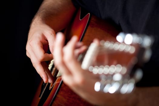 Close up on hands playing on folk guitar