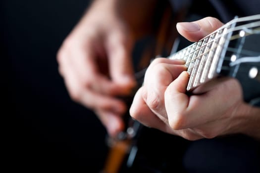 Close up on hands playing on electric guitar