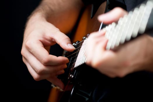 Close up on hands playing on electric guitar