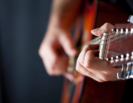 Close up on hands playing on folk guitar