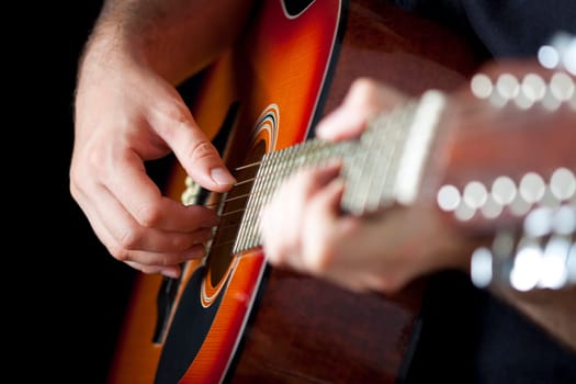 Close up on hands playing on folk guitar