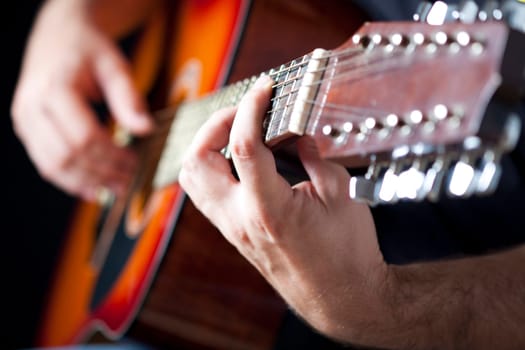 Close up on hands playing on folk guitar