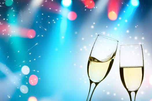 Two glasses of champagne with colorful lights in the background