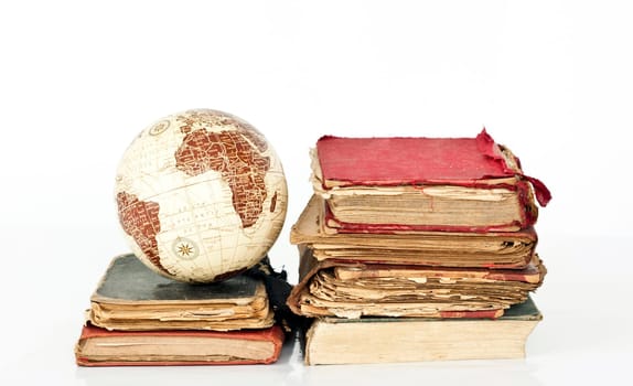 Old books and globe earth isolated on white