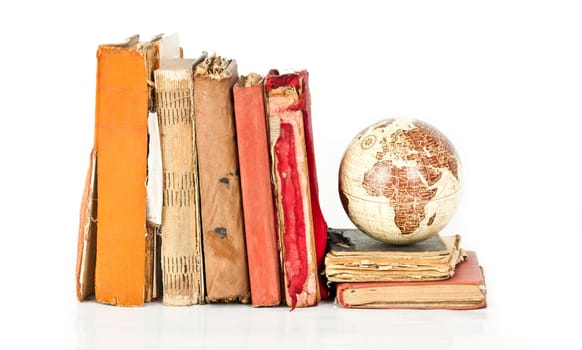 Old books and globe earth isolated on white