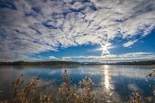 The Riedsee in the Black Forest,cloud formation and the low sun reflected in the lake.