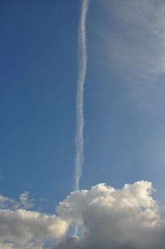 Blue sky airplane smoke trail and clouds. Abstract travel background.
