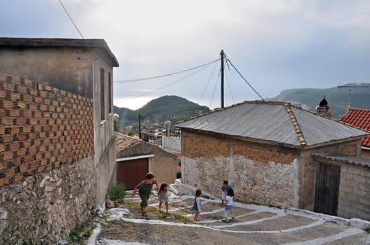 ZAKYNTHOS - MAY 6: Children playing on narrow alley, mountain village Keri, island of Zakynthos, Greece, May 6, 2013.