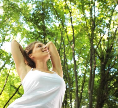 Beautiful woman enjoying the nature in green forest