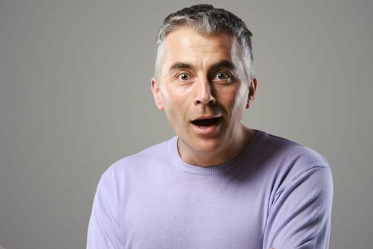 Portrait of casual man surprised on grey background