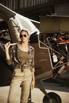 Woman airplane mechanic. Airplane on the background