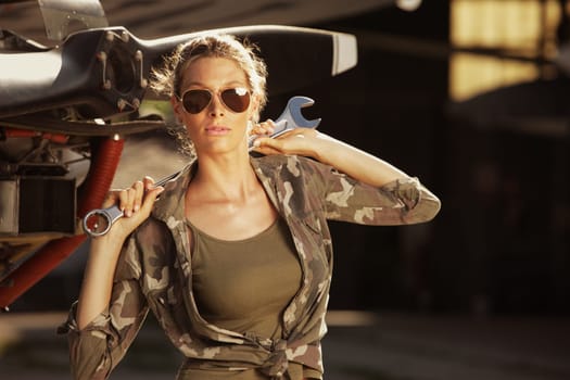 Woman airplane mechanic. Airplane on the background