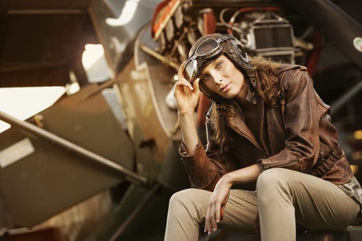 Portrait of young woman airplane pilot. Airplane on the background