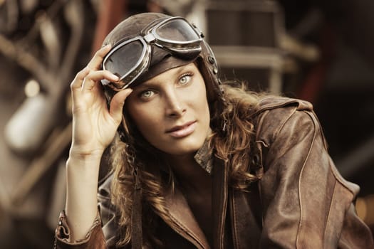 Portrait of young woman airplane pilot. Airplane on the background