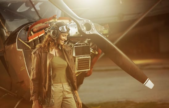 Portrait of beautiful woman aviator in airport at sunset