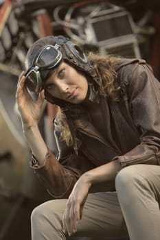 Portrait of young woman airplane pilot. Airplane on the background