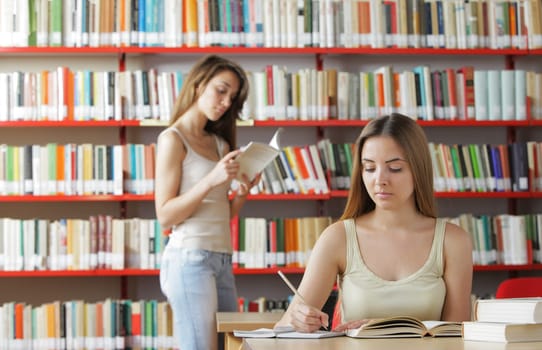 Portrait of a student in a library, student reading a book on background