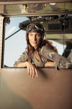 Portrait of young woman pilot in a military airplane. Copy space