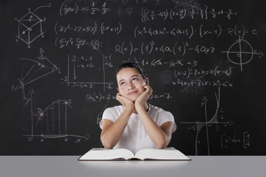 Student sitting in front of a blackboard filled with mathematical formulas. thinks about his future