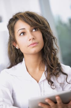 Handsome businesswoman thinking using his digital tablet