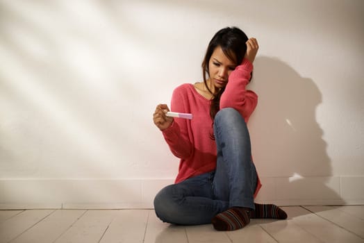Women and health, anxious Asian girl looking at pregnancy test kit, sitting on ground at home