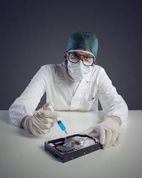Computer virus concept. Technical / Doctor with syringe and hard disk