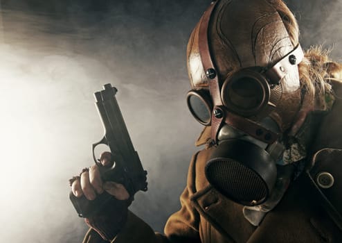 grunge portrait man witu gun in gas mask