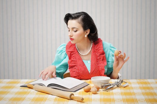Young woman looking at a Recipe for a cake